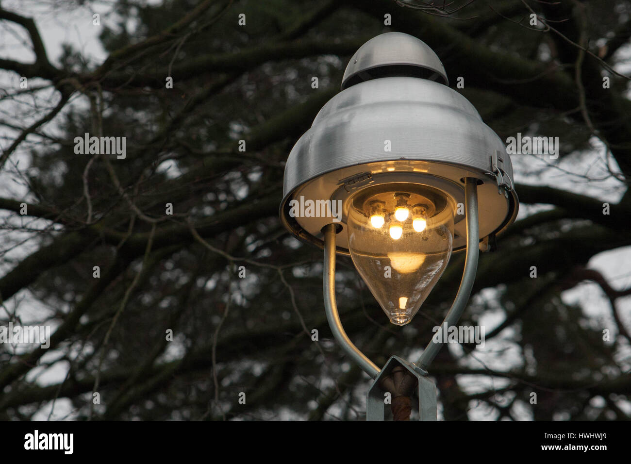 Historical four-burner gas lantern in Berlin Zehlendorf. The Photograph was captured shortly before the evening dusk, on the a cloudy day. Stock Photo