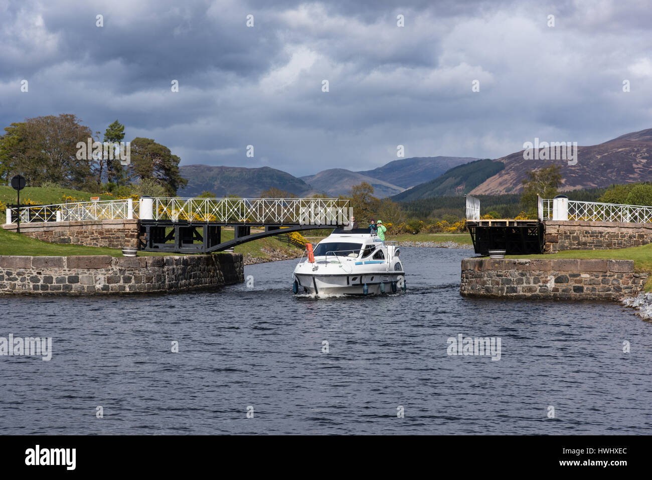 Motor Cruiser passing Moy Swing bridge, Caledonian Canal, Highlands, Scotland, UK. Stock Photo