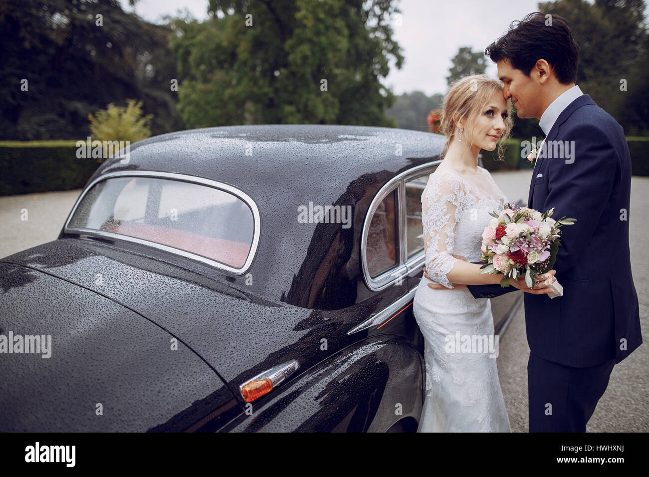 bride and groom standing in the yard near the car Stock Photo - Alamy