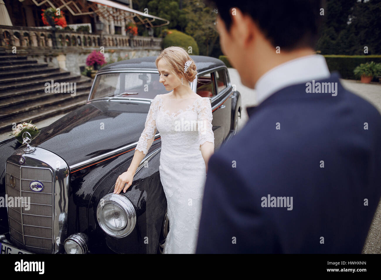 bride and groom standing in the yard near the car Stock Photo - Alamy