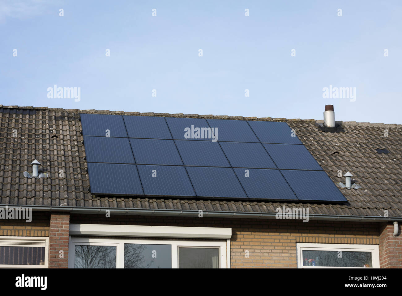 PV panels for sustainable energy on a roof of residential house in the Netherlands Stock Photo