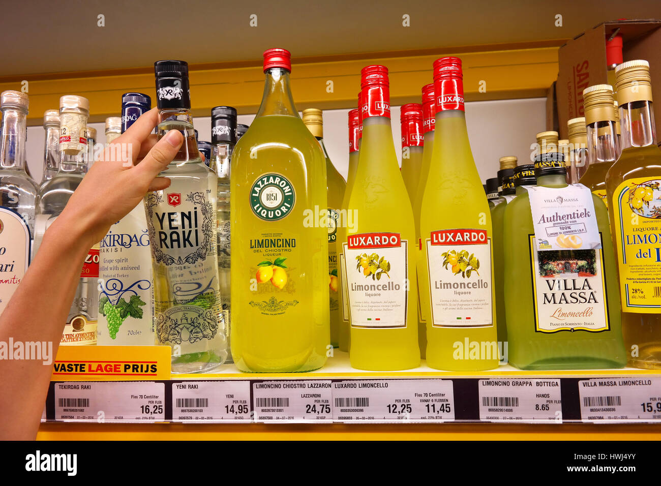 A customer picks a bottle of raki at a shop Stock Photo