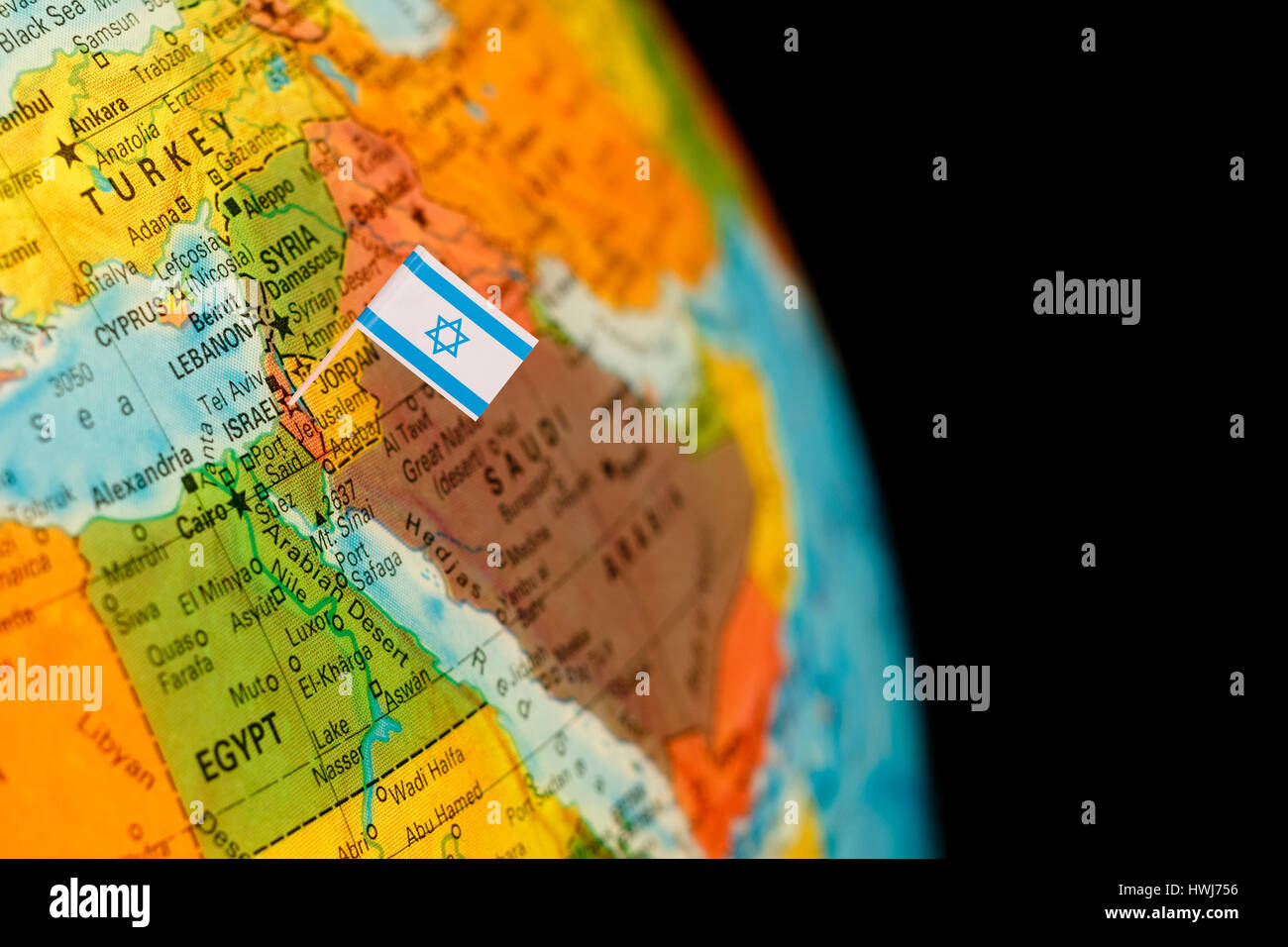 map with miniature flag of Israel .Selective focus on Israeli Flag.  Detail Globe Backlit lighting Stock Photo