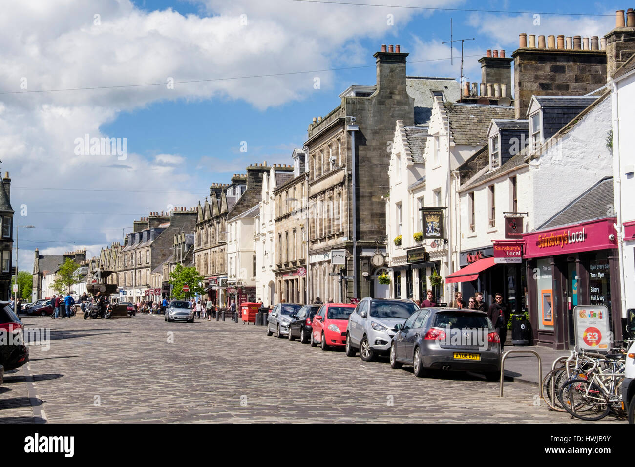 Street scene with cars parked roadside by shops in town centre in summer. Market Street, Royal Burgh St Andrews, Fife, Scotland, UK, Britain Stock Photo