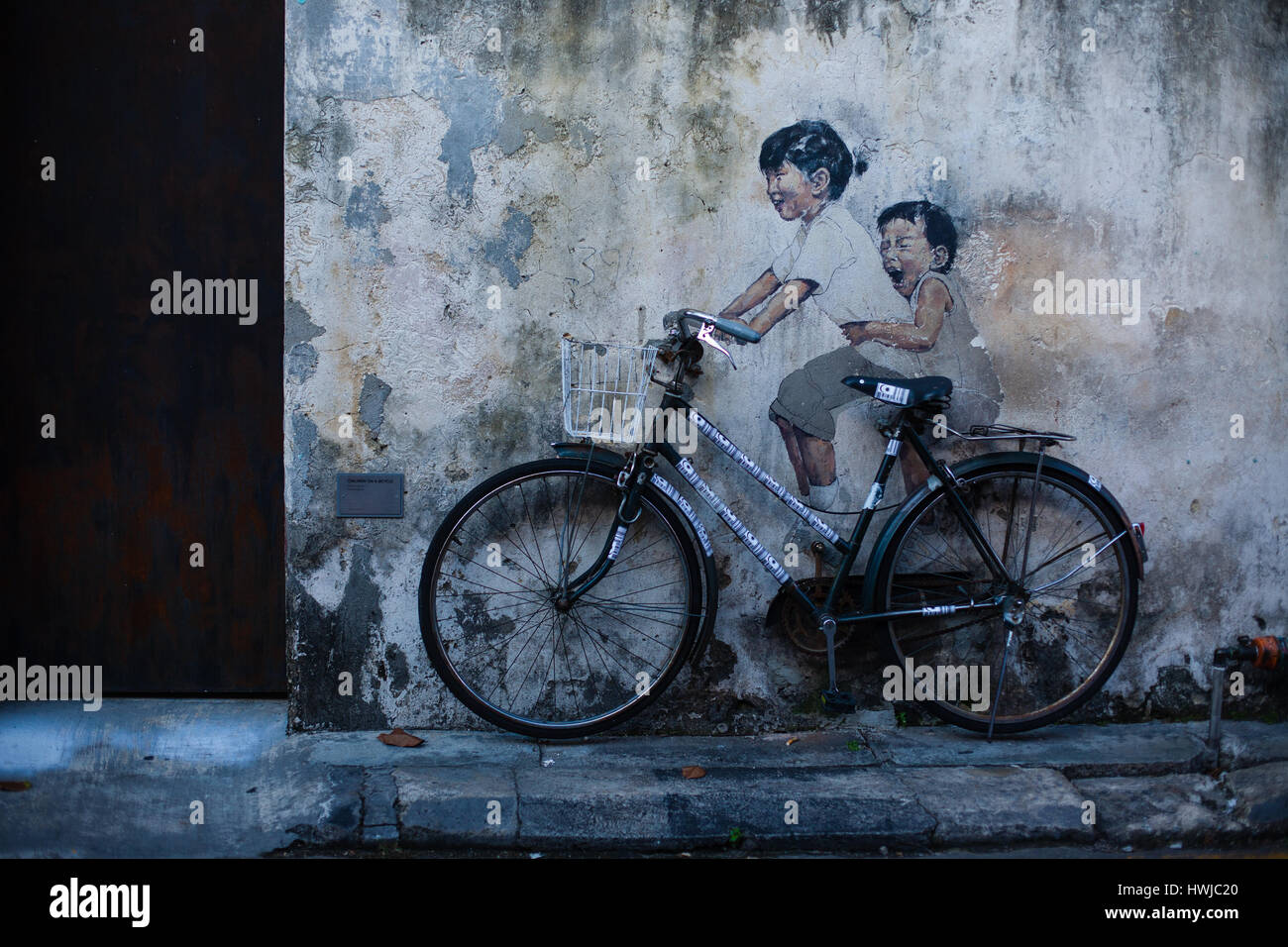 Graffiti with happy children, bike on the wall Stock Photo