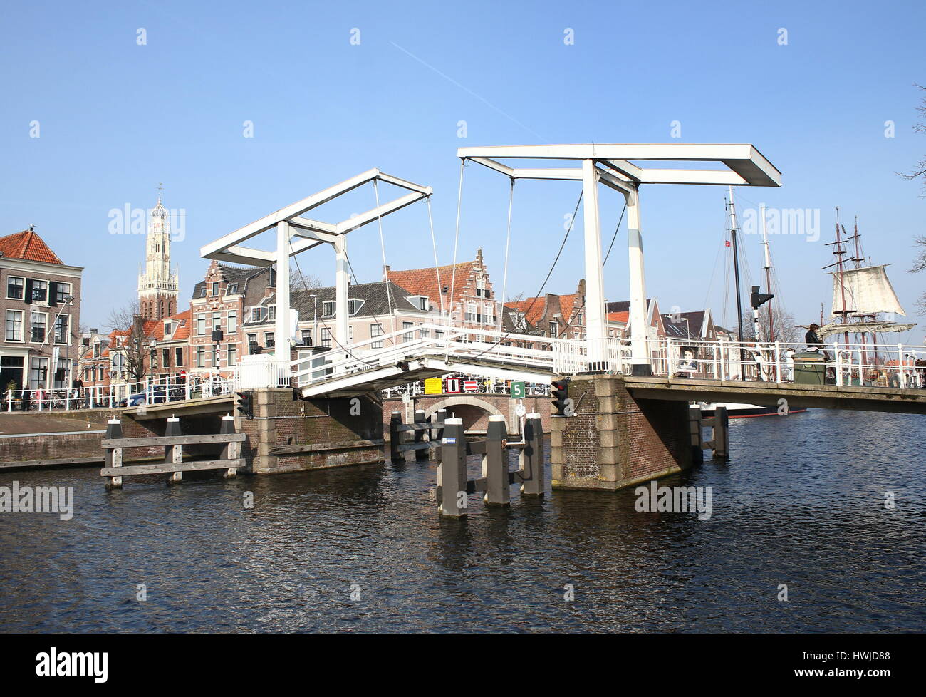 17th century Gravestenenbrug bridge over Spaane River in the historical city of Haarlem, The Netherlands. In background Bakenesserkerk church tower. Stock Photo