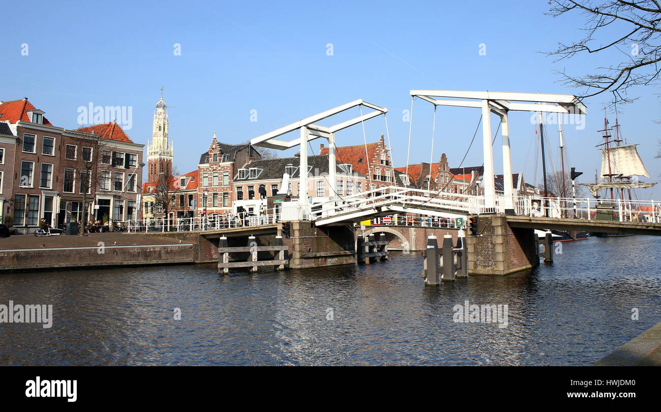 17th century Gravestenenbrug bridge over Spaane River in the historical city of Haarlem, The Netherlands. In background Bakenesserkerk church tower. Stock Photo