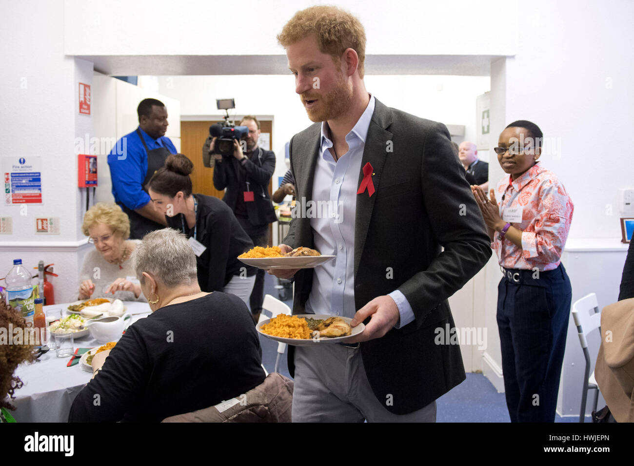 Prince Harry helps kitchen workers serve food to service users and