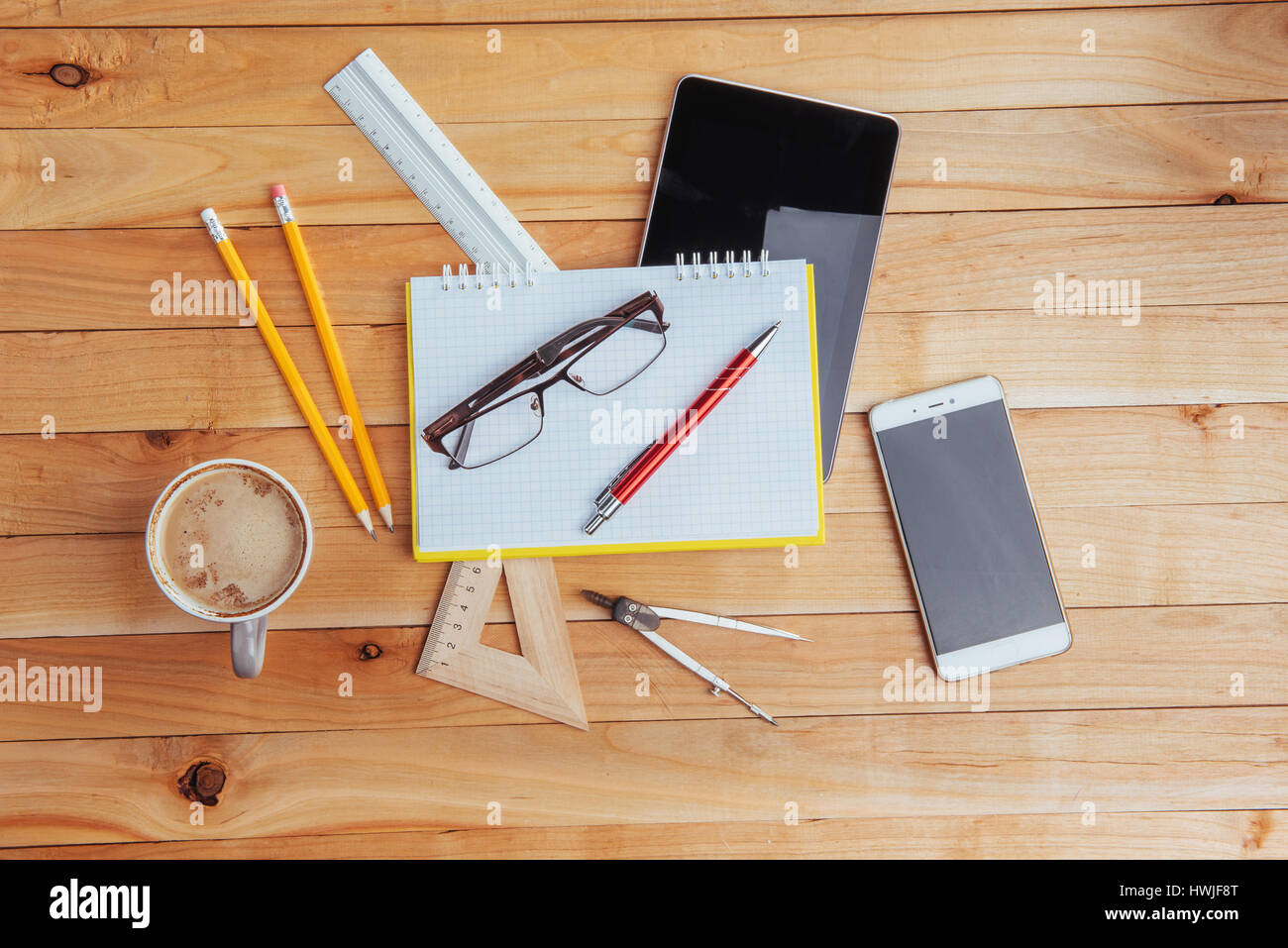 Top view of notebook, stationery, drawing tools and a few glasses
