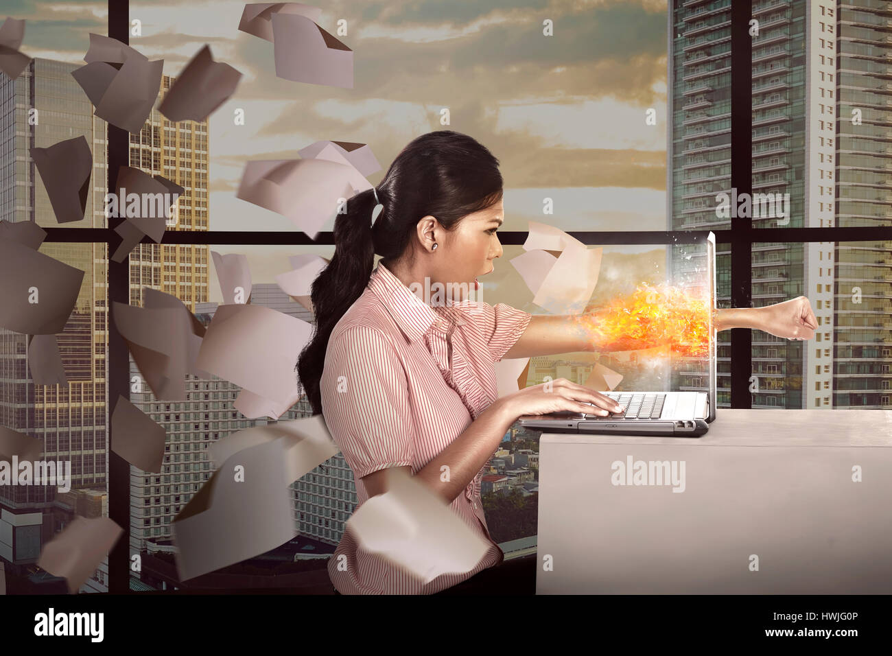 Business woman get angry with her job. She punch her laptop Stock Photo