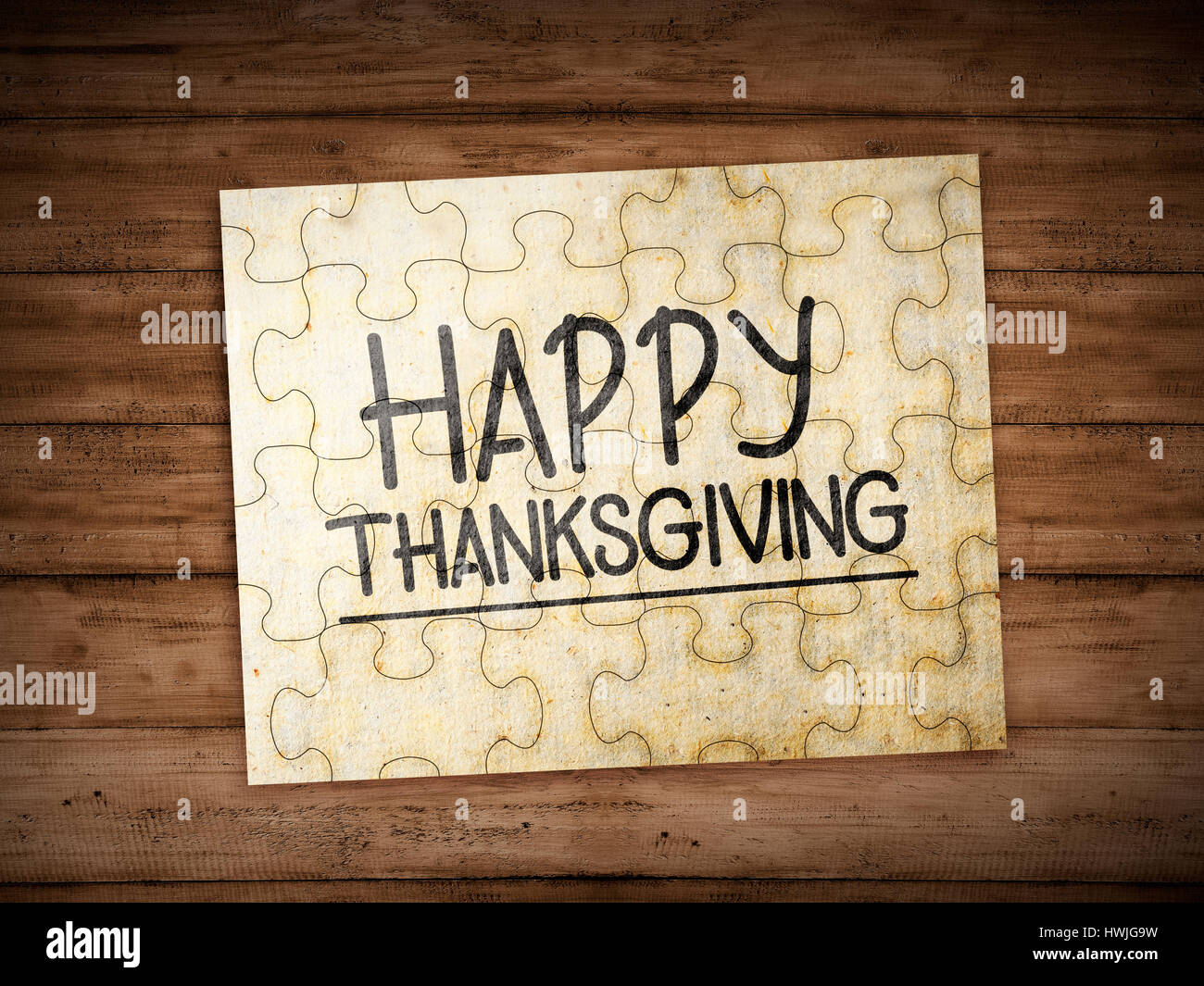 Happy thanksgiving text on the puzzle over wooden background Stock Photo