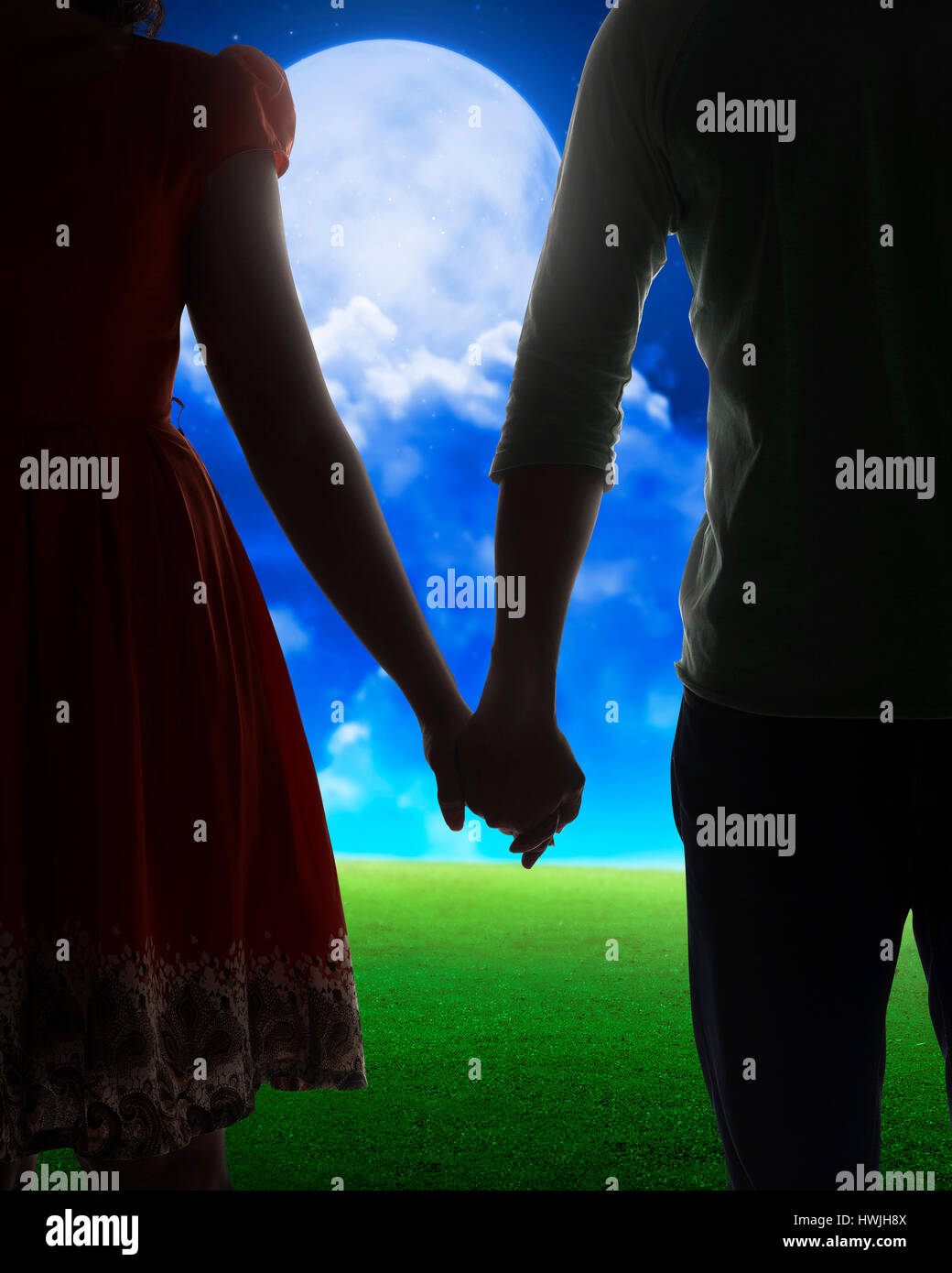Young couple silhouette on a field on field background Stock Photo