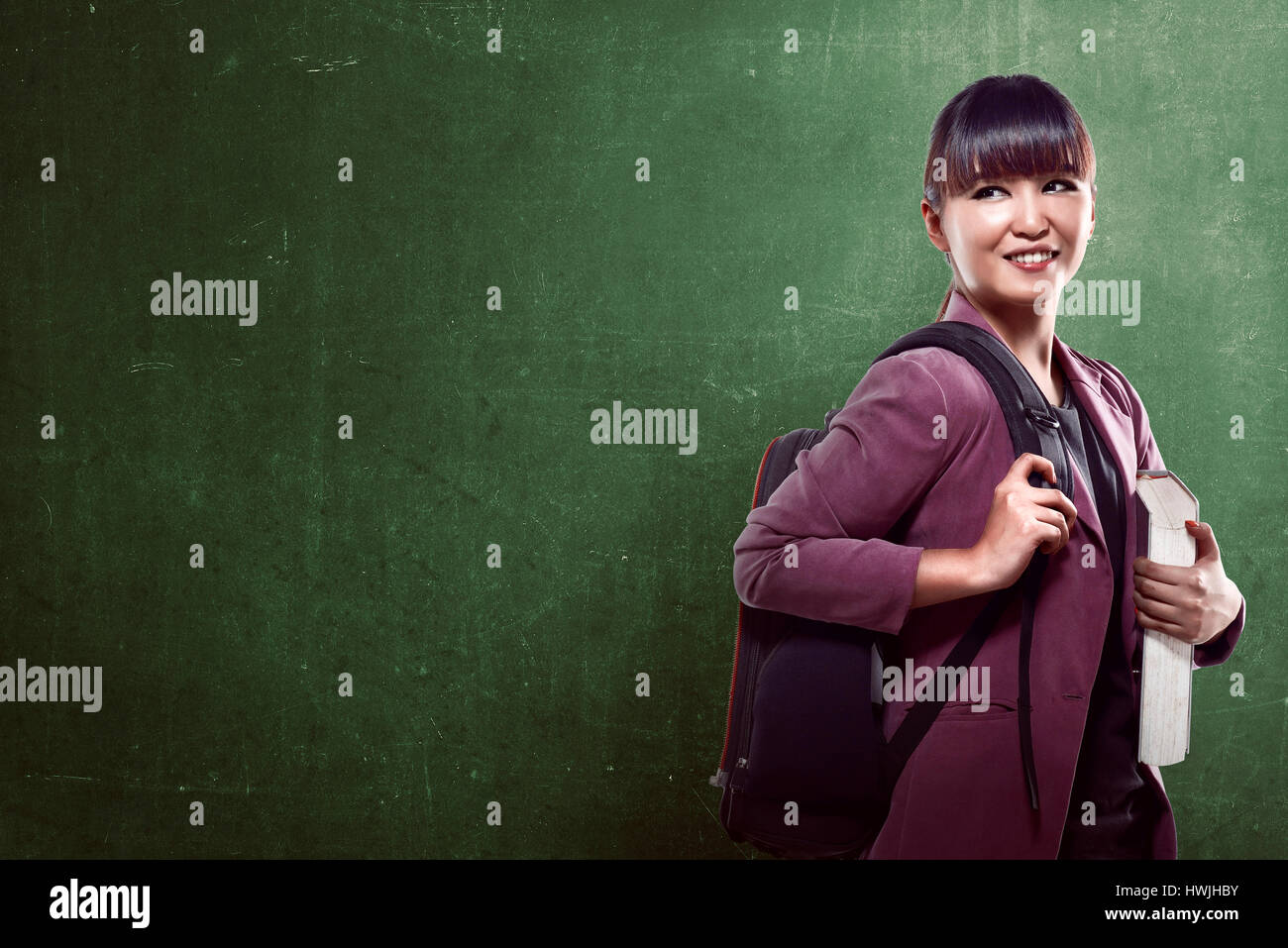 Asian college girl smiling with blackboard background Stock Photo