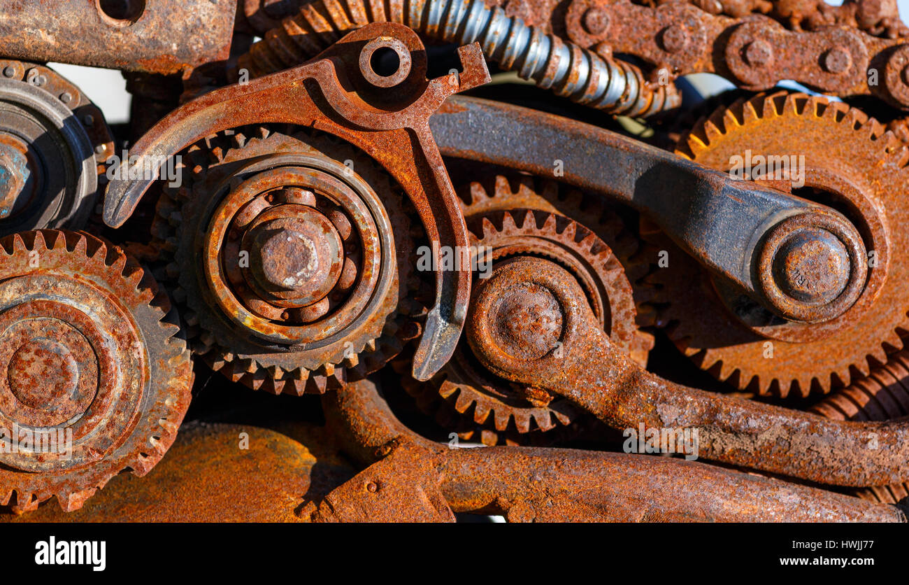 Part of the old mechanism with metal gears, sprockets, chain and other parts covered with rust. Stock Photo