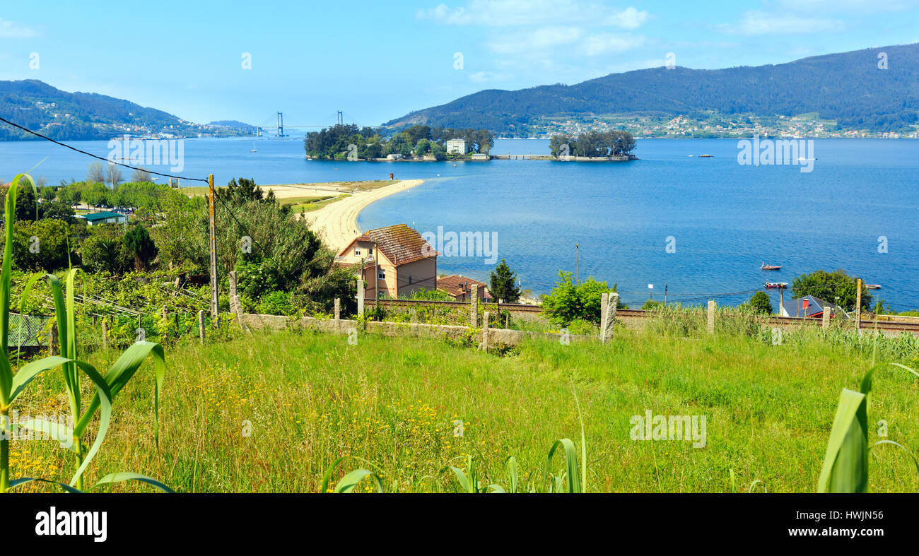 Sandy beach in Cesantes town and San Simon island (Galicia, Spain). Summer Ria de Vigo landscape. Stock Photo