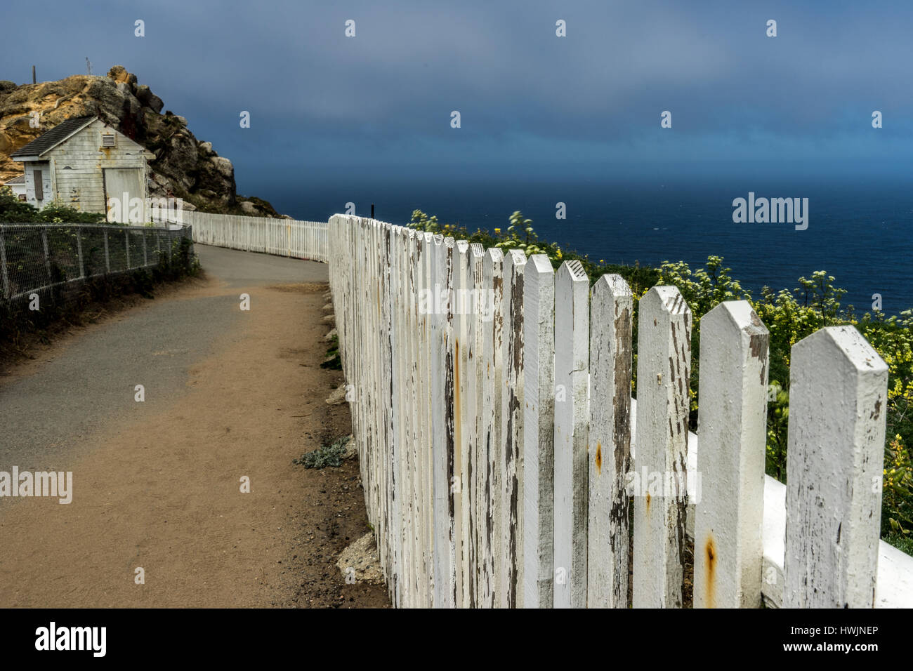 Weather worn white picket fence and shed at Point Reyes National