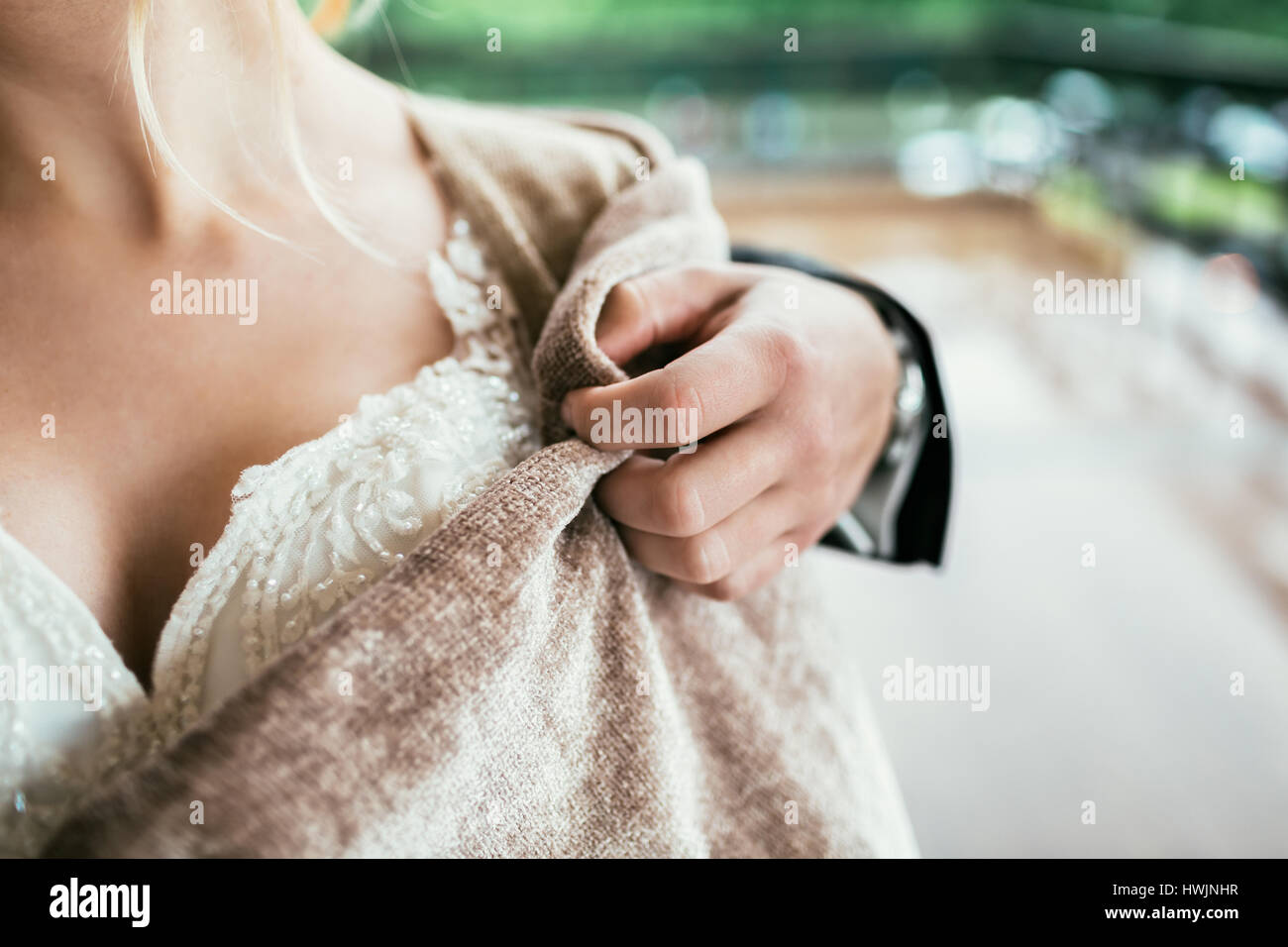 Groom help bride to wear a cape Stock Photo Alamy