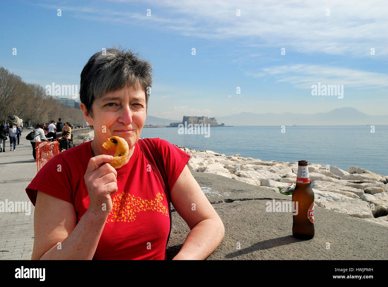 Naples, Italy. A tourist crunches a tarallo (ringshaped biscuit) and a