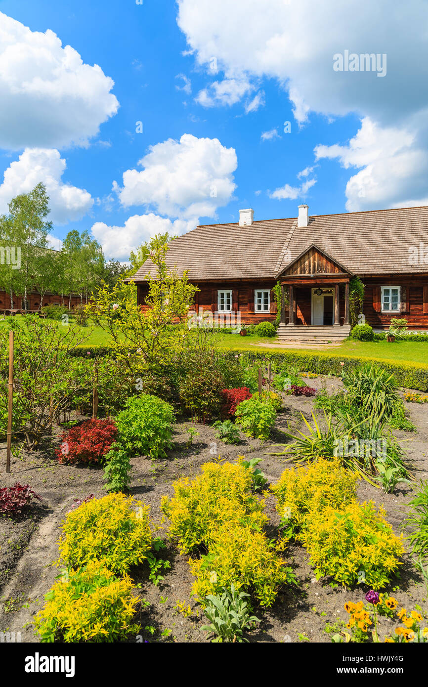 Old traditional manor house and beautiful garden in Tokarnia village on sunny spring day, Poland Stock Photo