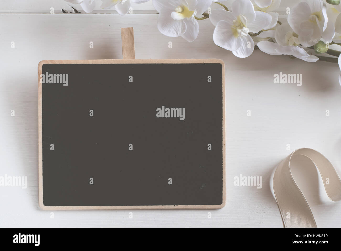 Blank chalkboard with flower bouquet on wooden table. Stock Photo