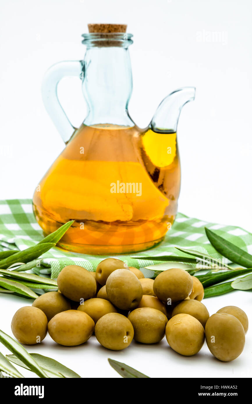 Green olives, olive oil and olives leaves on a white background Stock ...