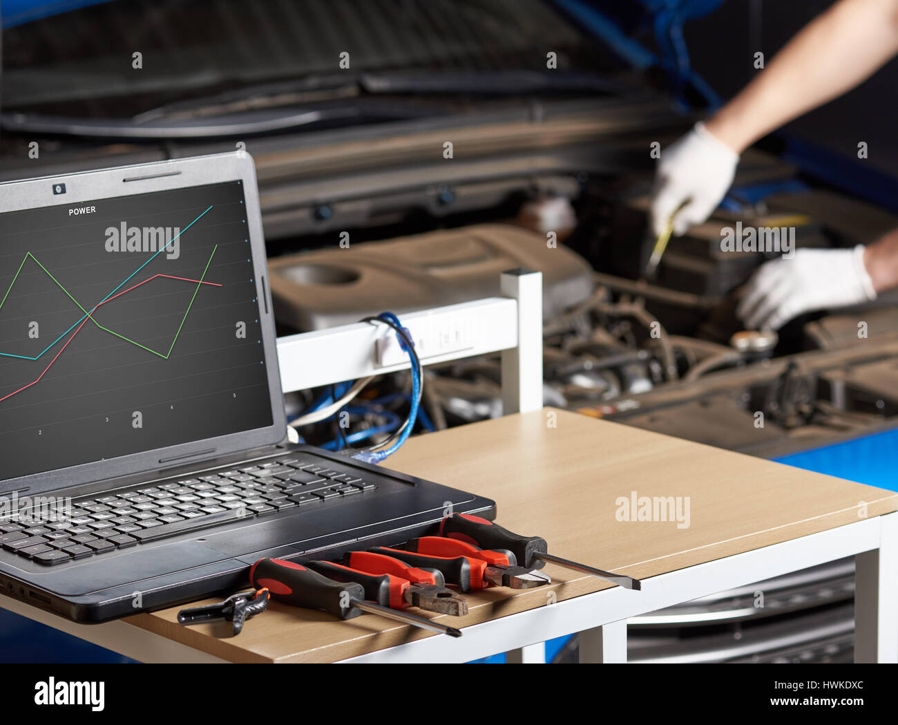 Computer diagnostic of modern car. Mechanic checking engine of car