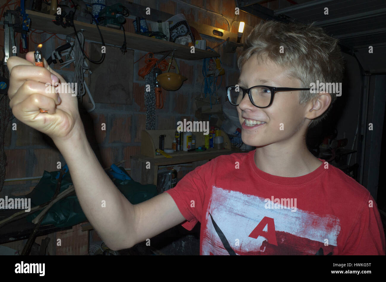 Polish boy age 12 starring and captivated by the flame from his cigarette lighter. Zawady Central Poland Europe Stock Photo