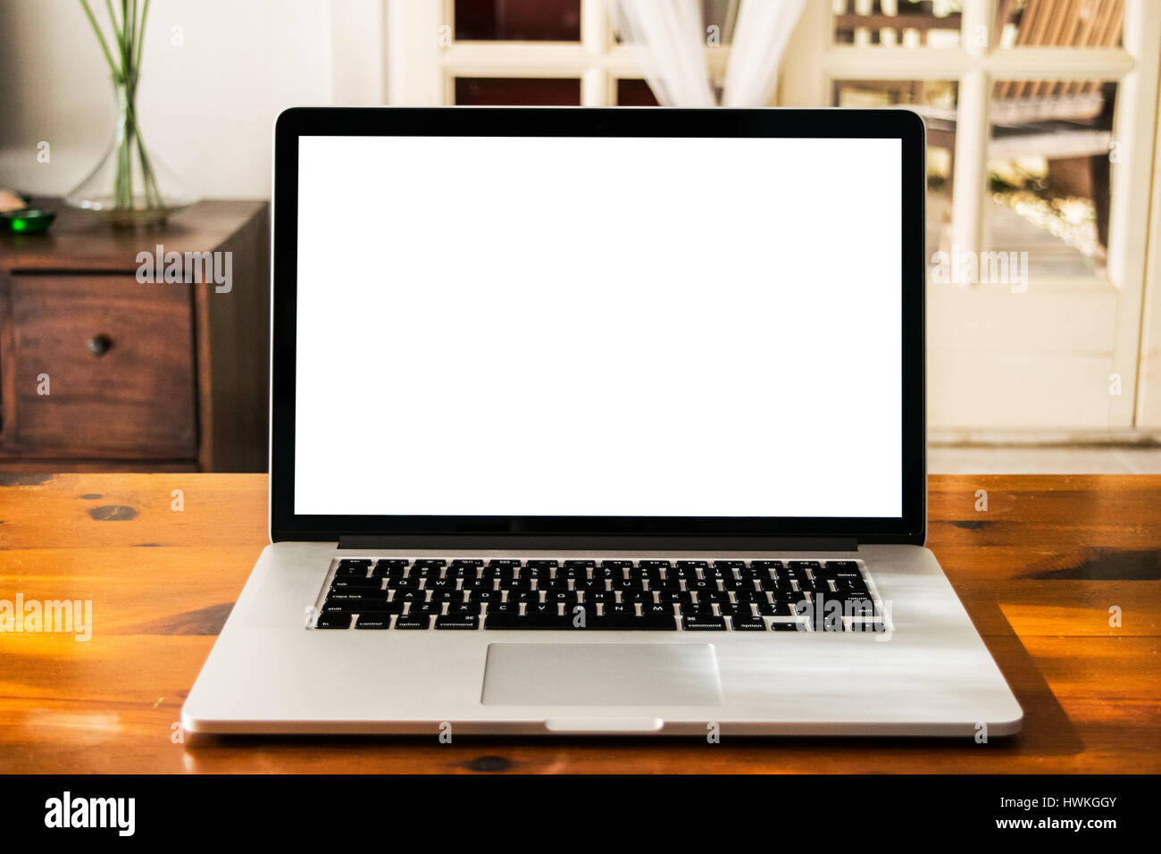 Silver laptop with blank white screen on the wooden table in home ...