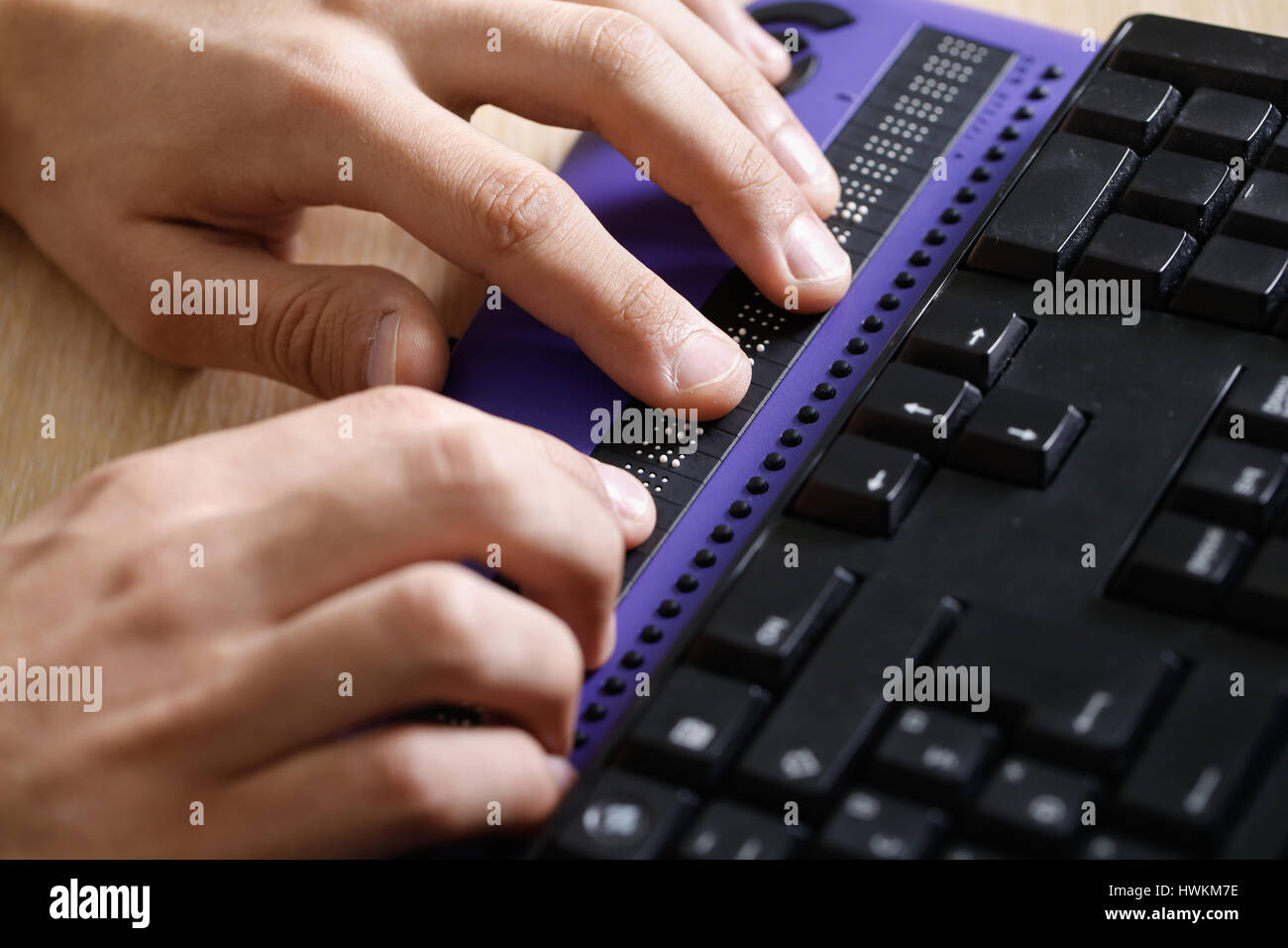 Blind person using computer with braille computer display and a