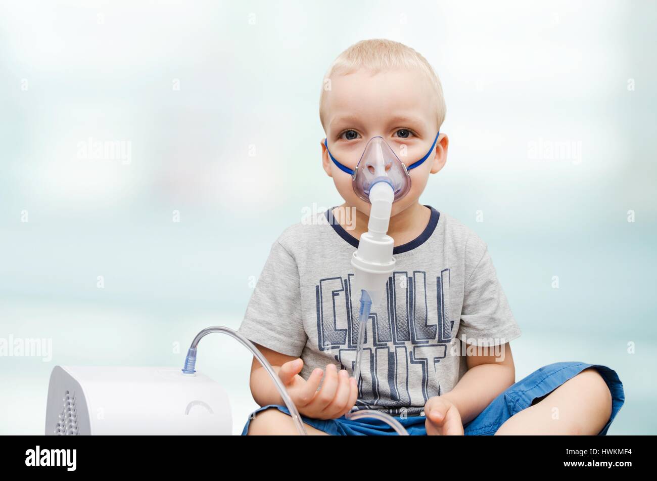 Child making inhalation with mask on his face. Asthma problems concept