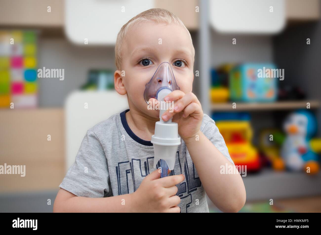 Child making inhalation with mask on his face. Asthma problems concept