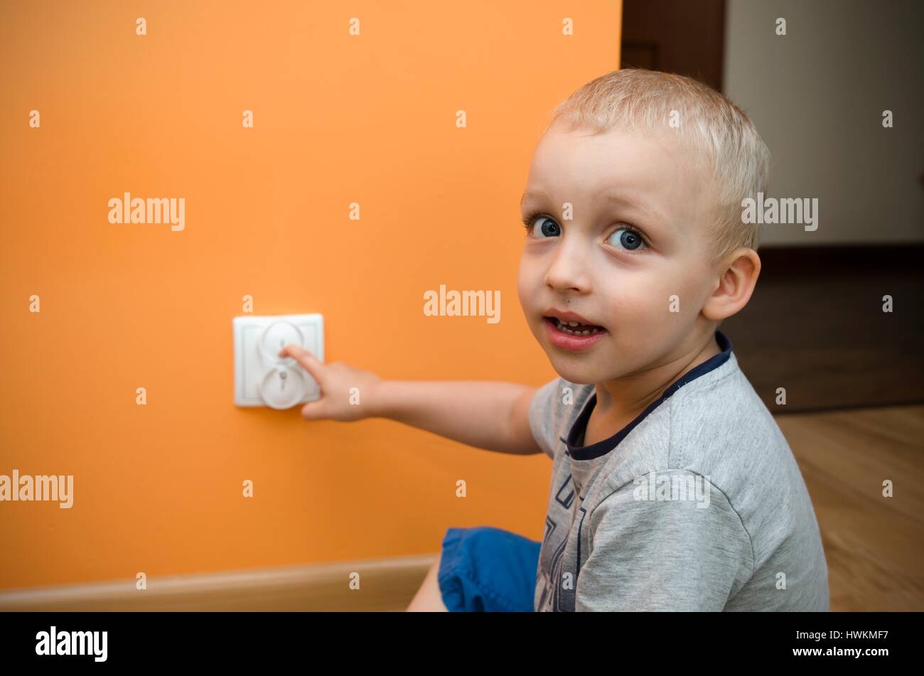 Child near to the socket. Electrical security of ac power for babies Stock Photo