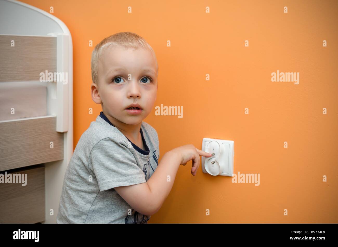 Child near to the socket. Electrical security of ac power for babies Stock Photo