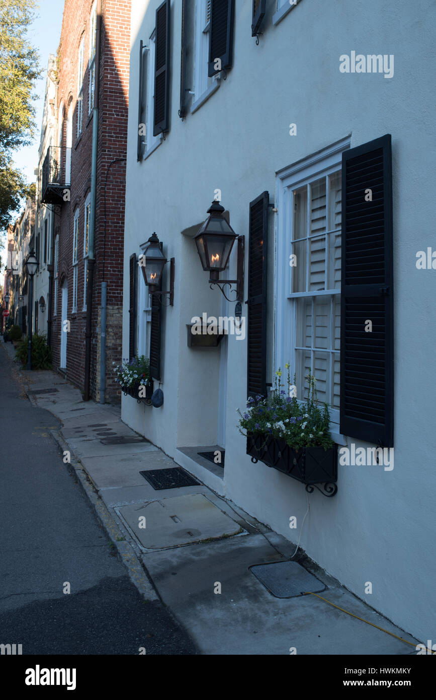 Gas Lights on wall of entry to historic Charleston, SC House with Shutters and Window Flower Boxes Stock Photo