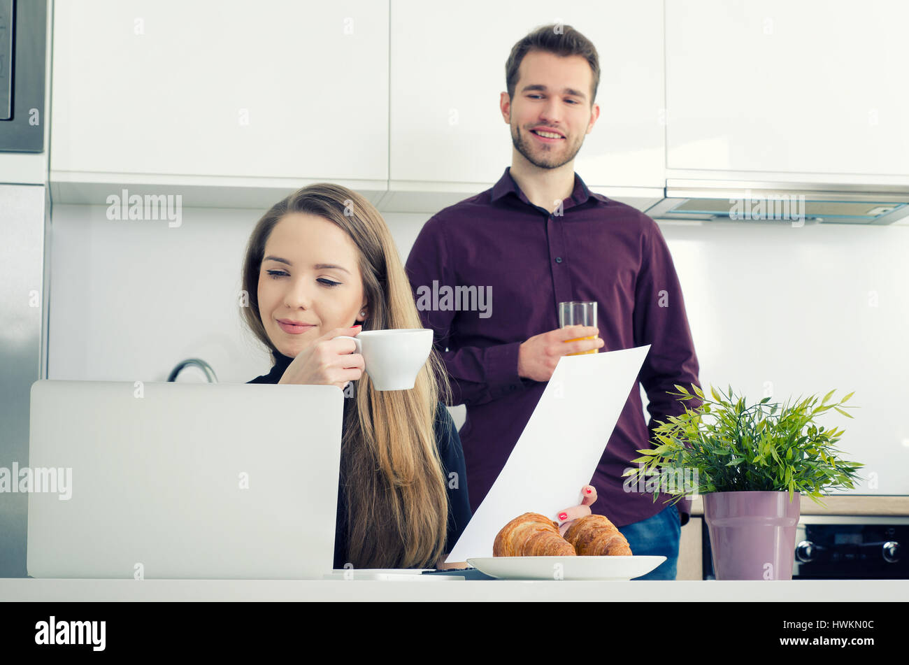 Young businesswoman working at home drinking coffee. home work woman laptop kitchen modern businesswoman couple concept Stock Photo