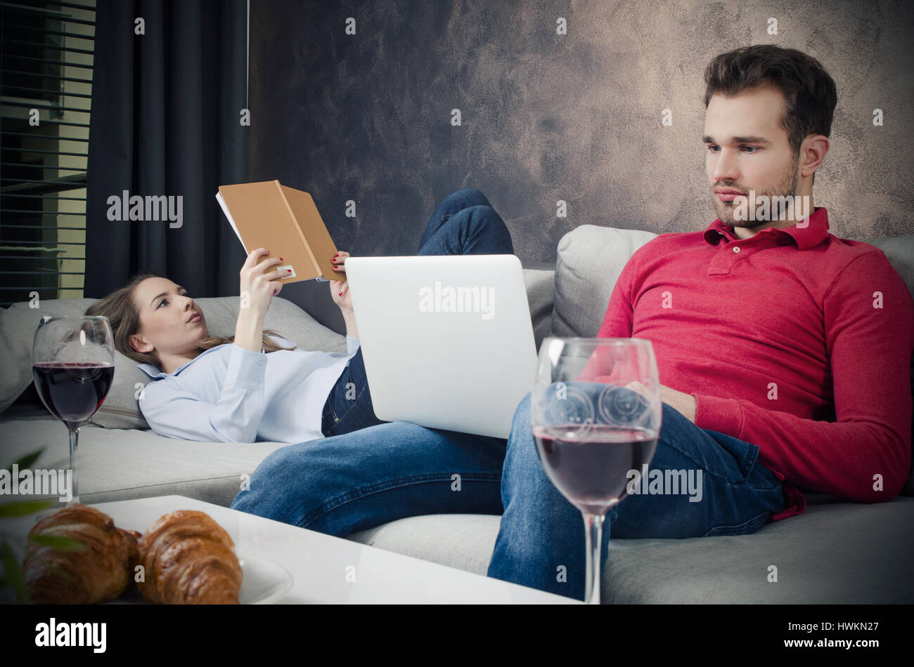 Couple enjoys free time. couple leisure reading book laptop internet home concept Stock Photo