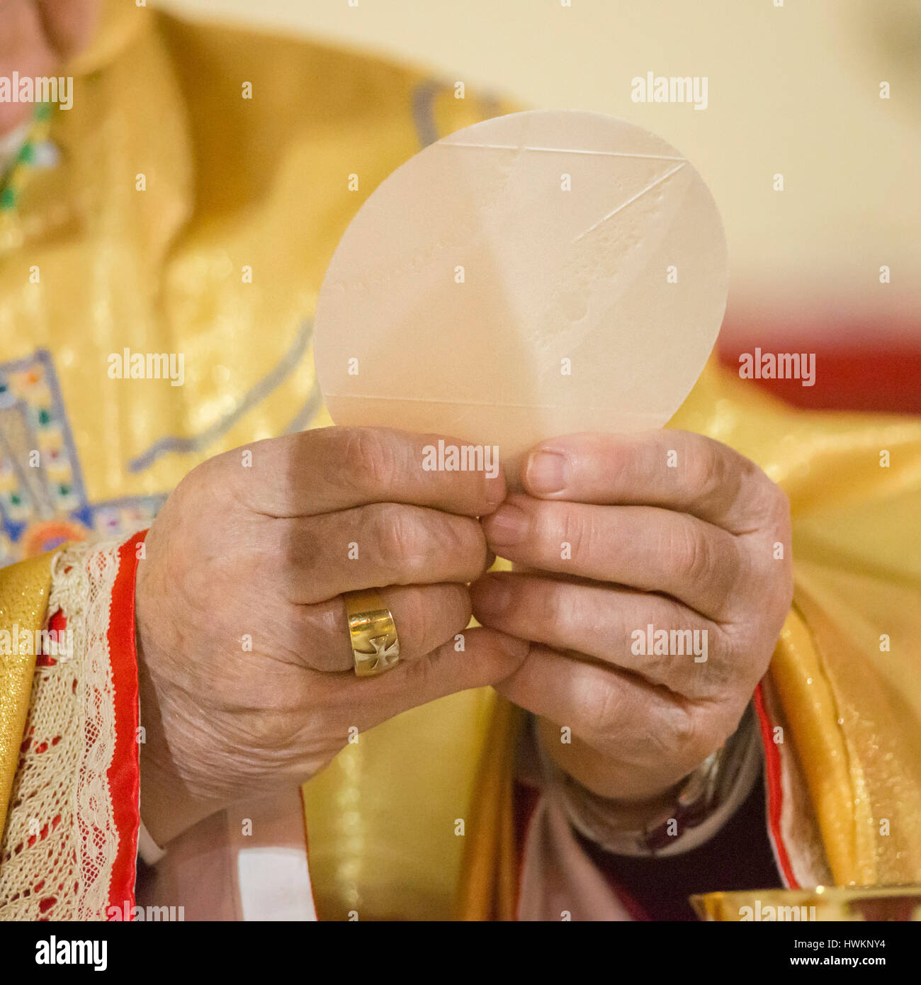 Bishop officiation mass during eucharist with holy bread and goblet ...