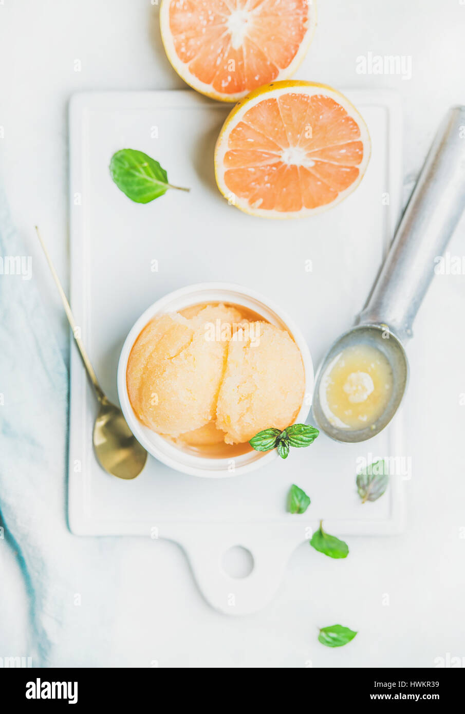 Pink grapefruit homemade sorbet with fresh mint leaves in white bowl on ...