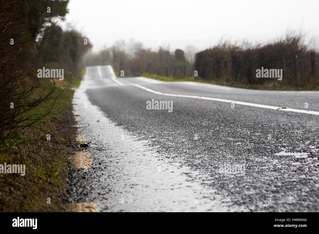 red cats eye on edge of the road on a wet irish rural road in county sligo Stock Photo