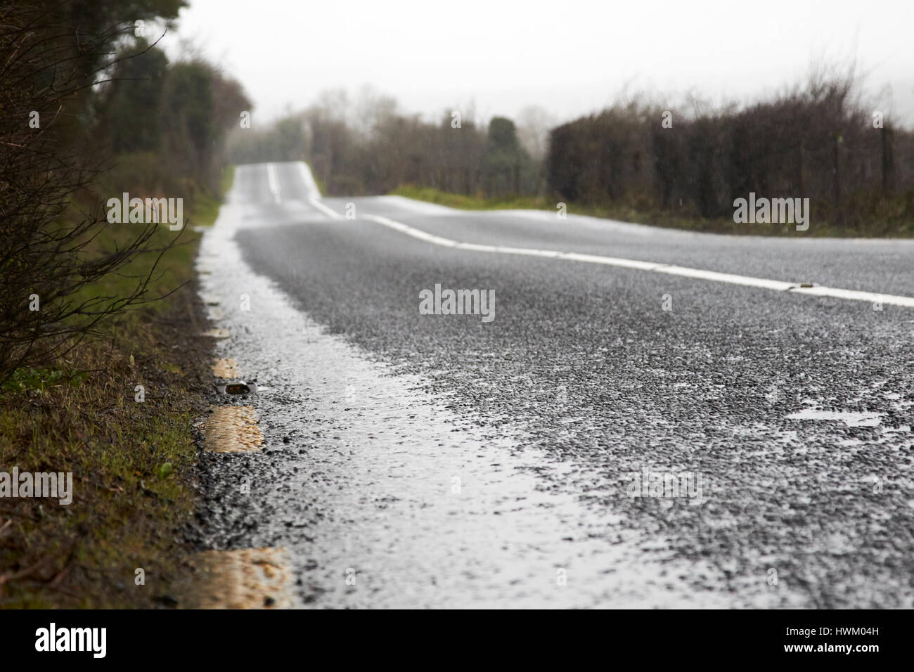 standing water on the edge of the road on a wet irish rural road in county sligo Stock Photo