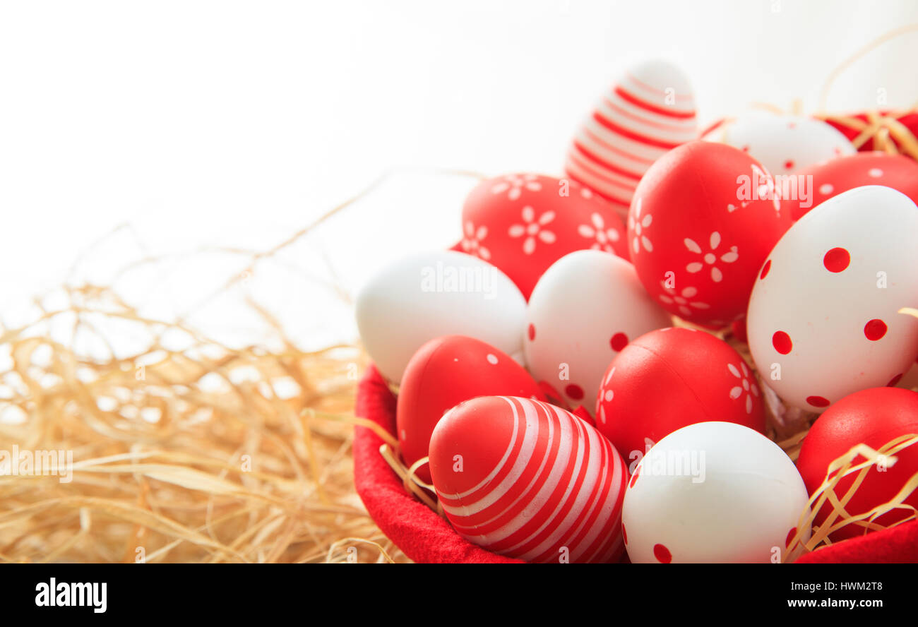 Colorful Easter eggs in a basket on straw background Stock Photo - Alamy