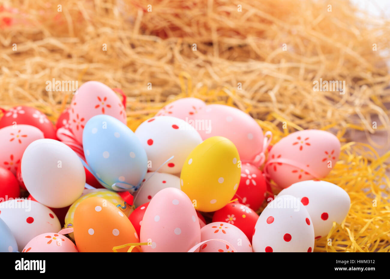 Colorful pastel Easter eggs on straw background Stock Photo - Alamy