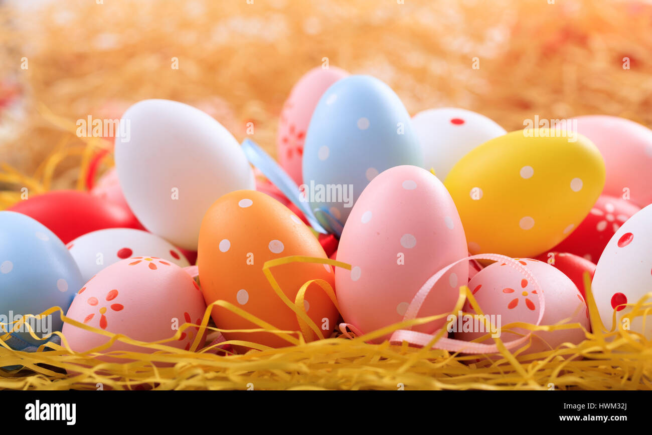 Colorful pastel Easter eggs on straw background Stock Photo - Alamy