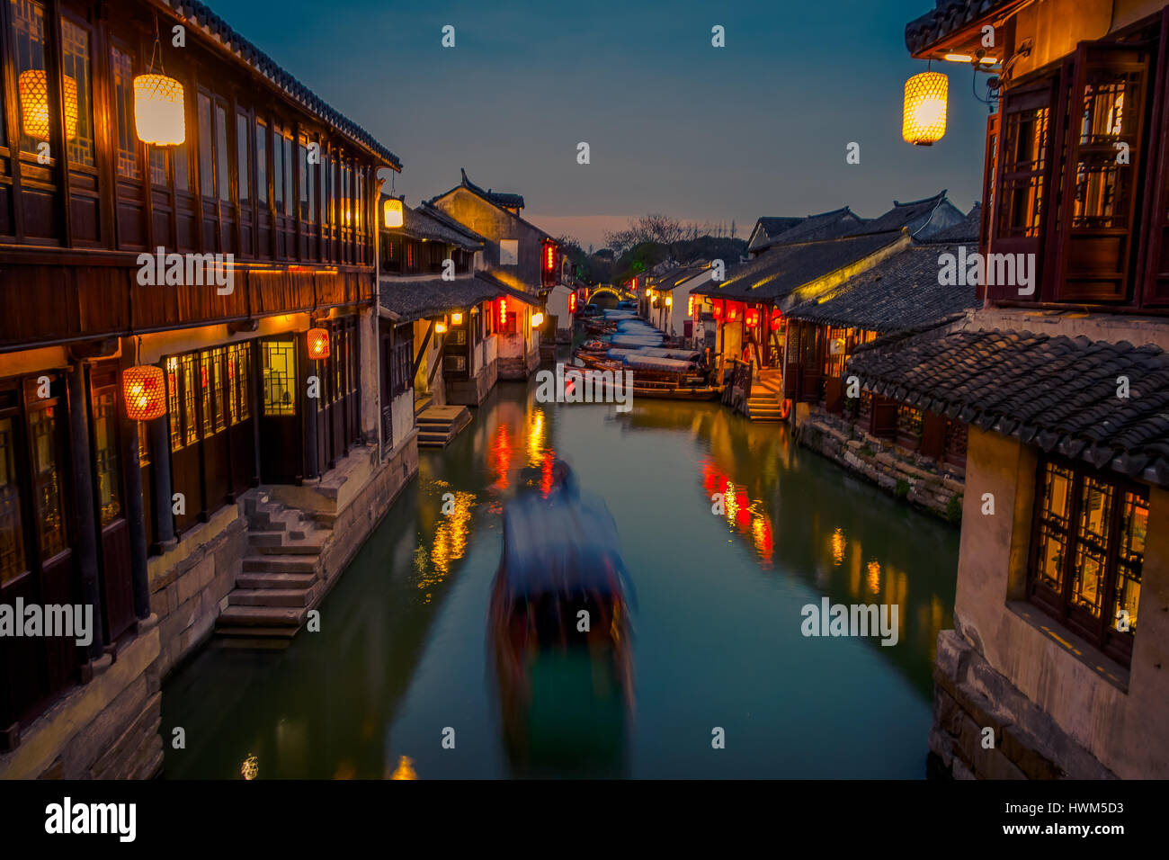 SHANGHAI, CHINA: Beautiful evening light creates magic mood inside Zhouzhuang water town, ancient city district with channels and old buildings, charming popular tourist area Stock Photo