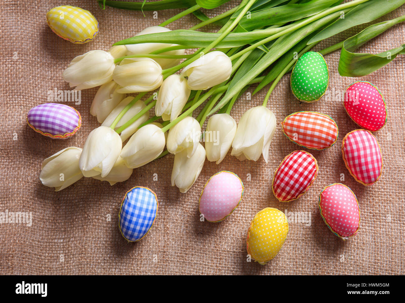 Colorful Easter eggs and white tulips on a burlap Stock Photo - Alamy
