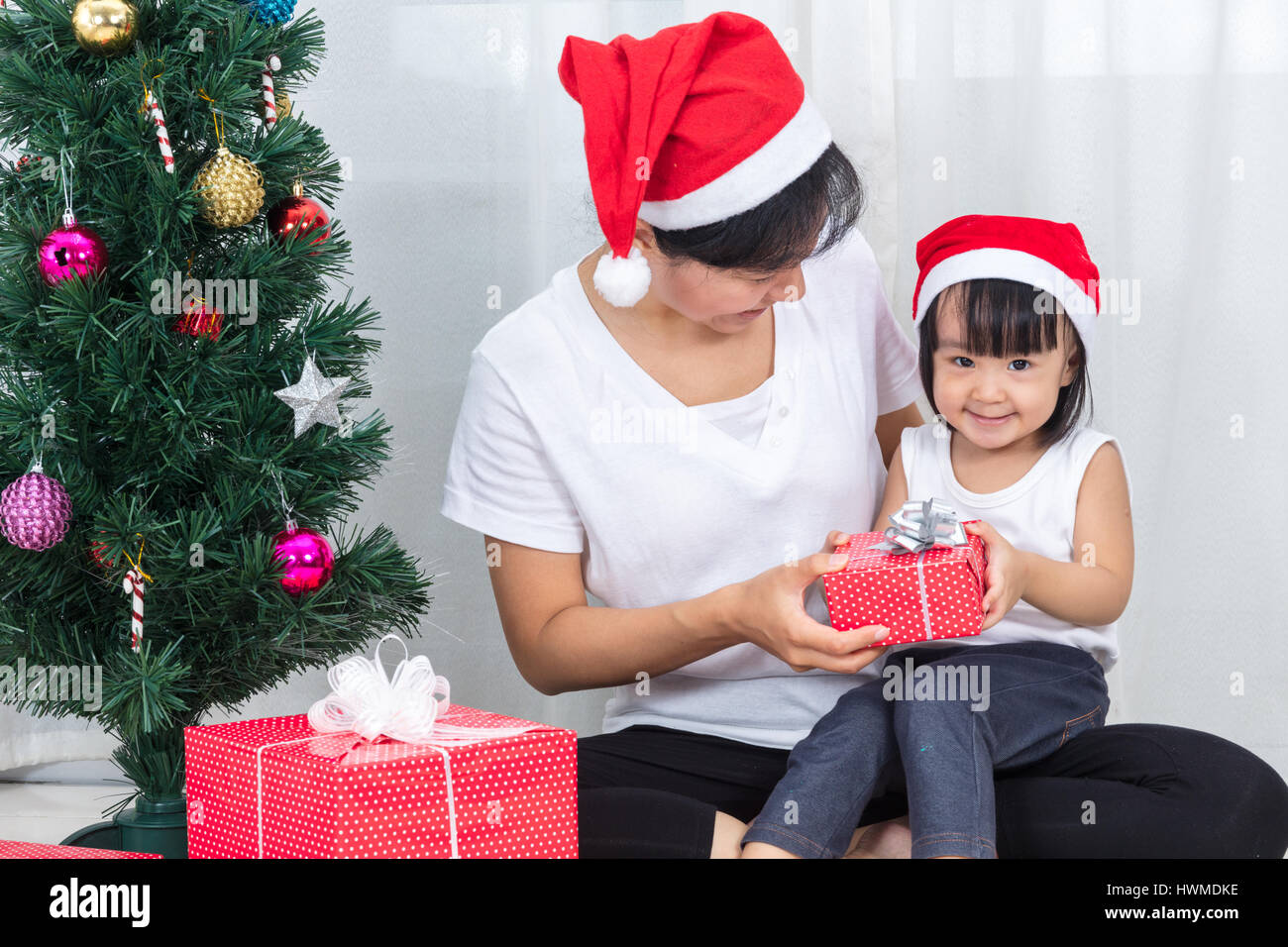 https://c8.alamy.com/comp/HWMDKE/asian-chinese-mother-and-daughter-sitting-next-to-christmas-tree-to-HWMDKE.jpg