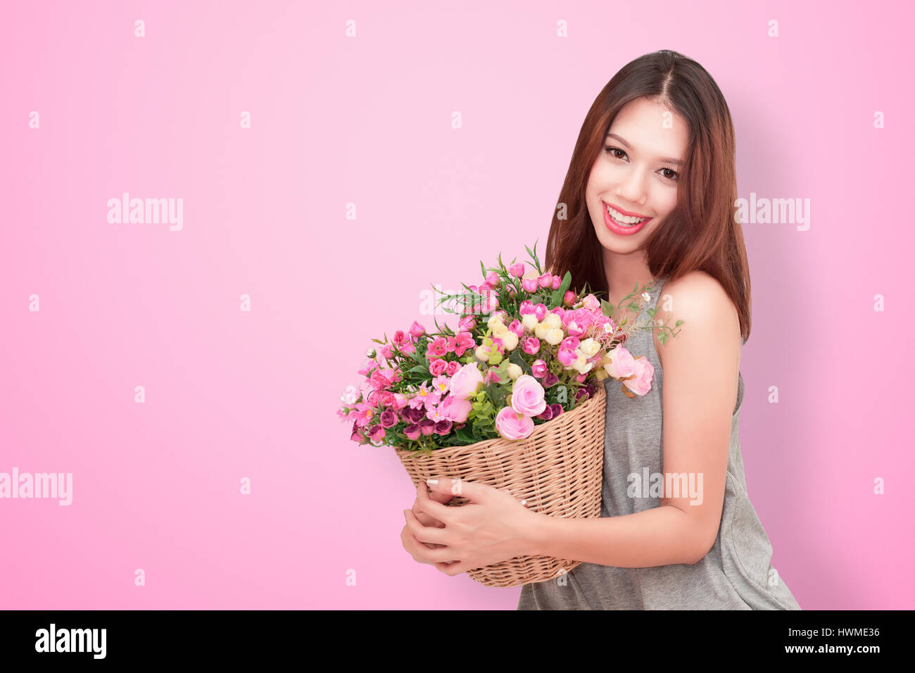 Girl holding a basket of flowers.  Isolated on white. Stock Photo