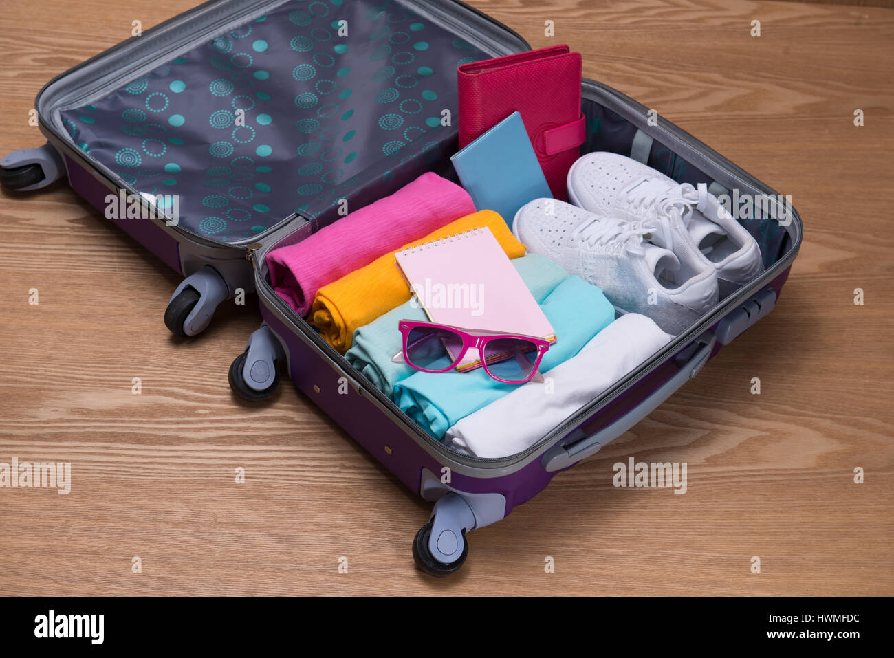 Travel and vacations concept. Open traveler's bag with clothing, accessories, credit card, tickets and passport. Stock Photo