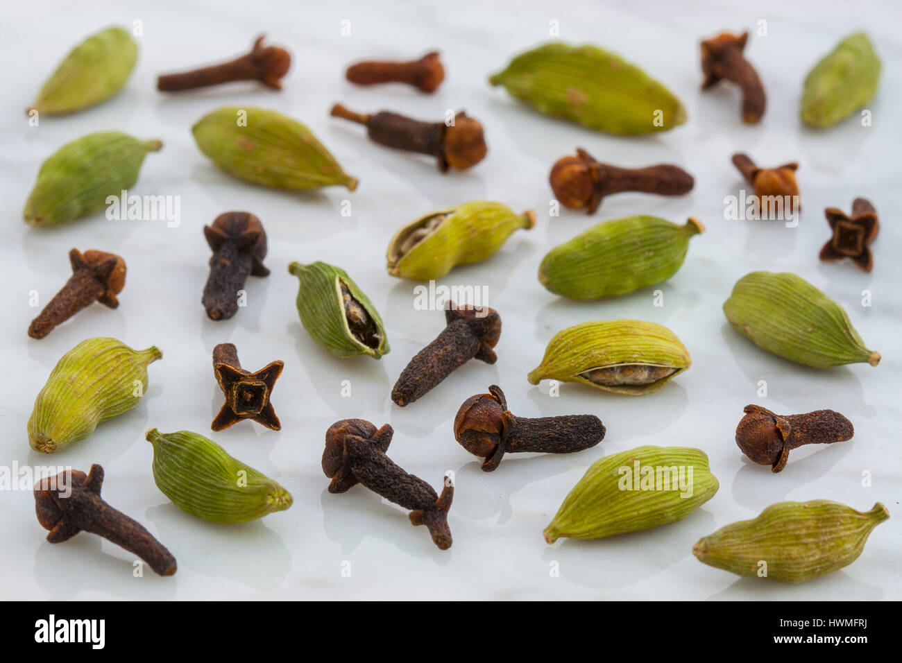 beautiful cardamom pods and cloves on top of carrara marble coutertop Stock Photo