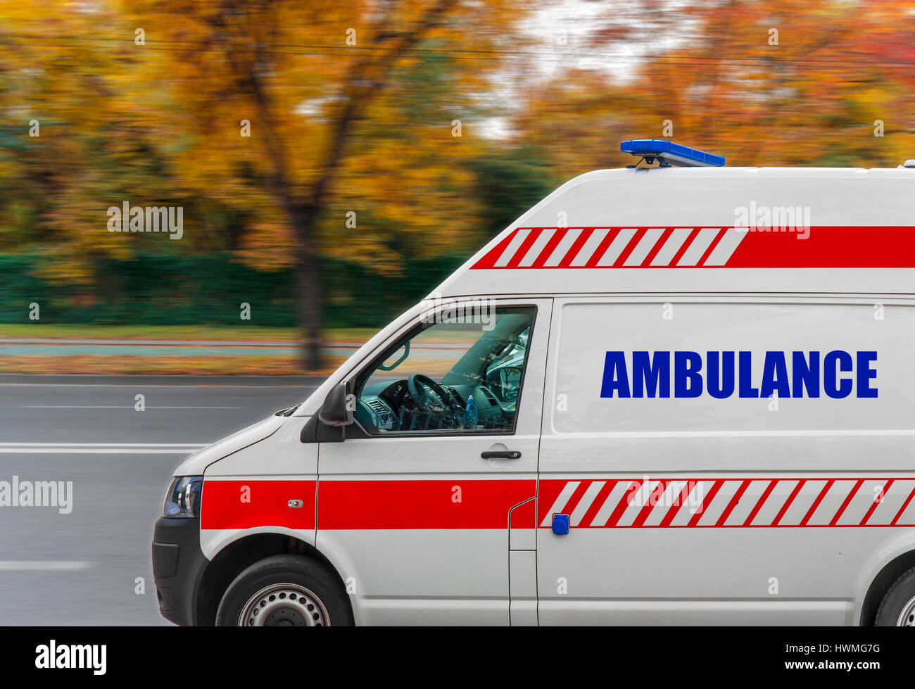 Ambulance service van driving fast on street Stock Photo Alamy